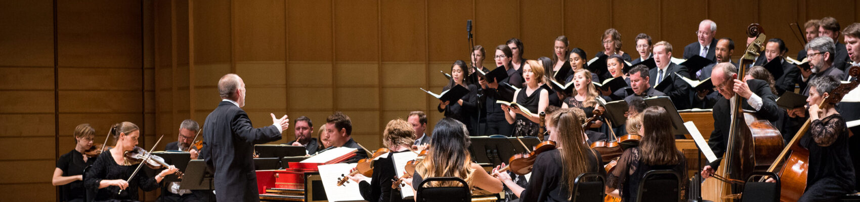 Pacific Baroque Orchestra on stage, led by Alex Weimann conducting from harpsichord
